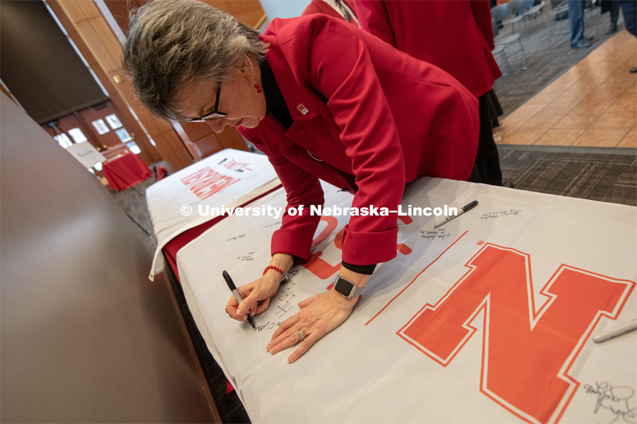 Jane Green, signs one of the four Alumni N150 flags. The flags will travel around the world to various alumni chapters and be signed. They will return in the fall and be hung for homecoming weekend for all to see. Everyone was invited to enjoy a cupcake and join in the festivities with their Husker friends at the Wick Alumni Center, Friday February 15th. The Nebraska Charter was available to view, along with other historical items. Copies of Dear Old Nebraska U could be purchased and signed. Charter Day at the Wick Alumni. February 15th, 2019. Photo by Gregory Nathan / University Communication.
